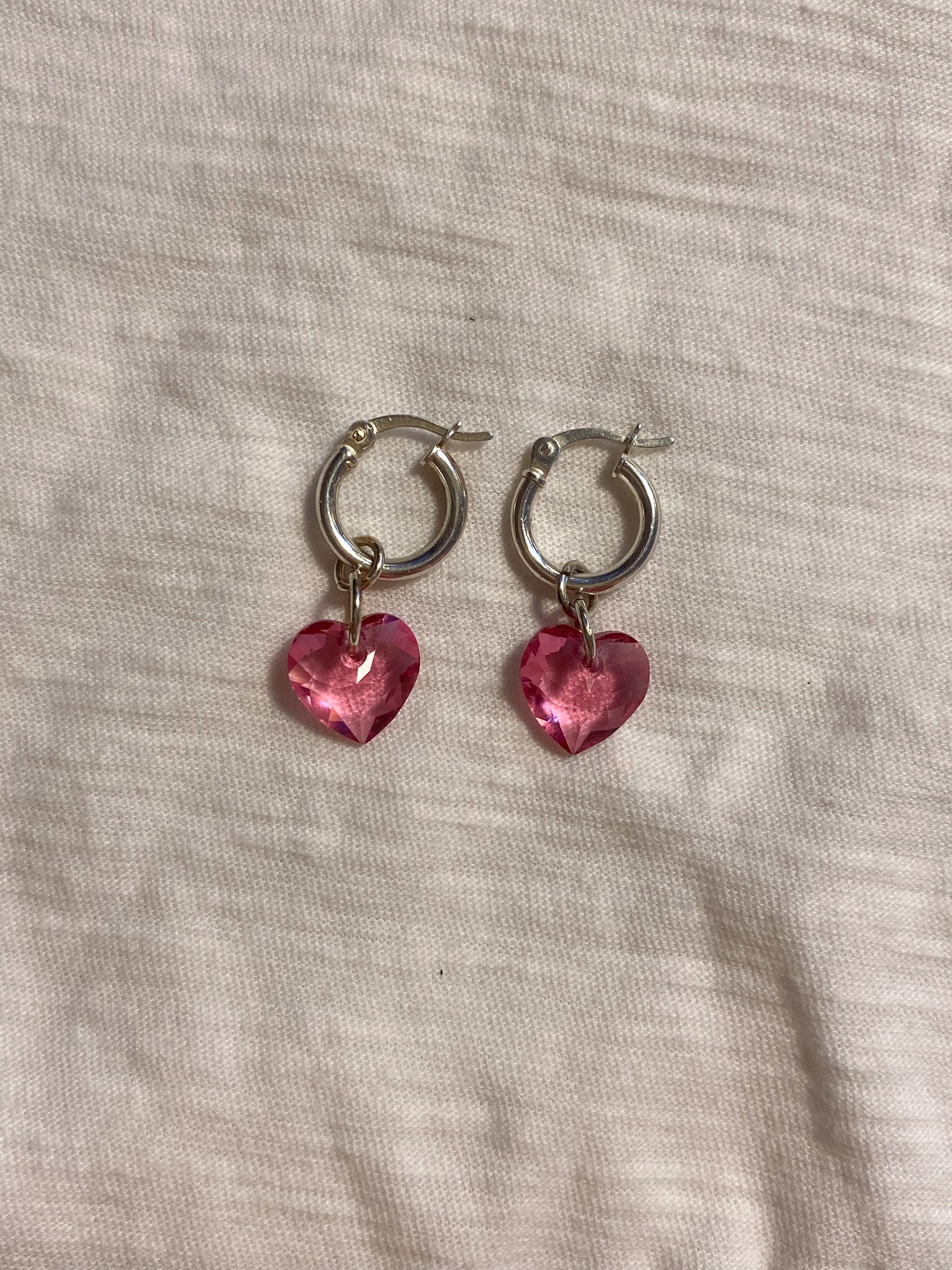 flat lay image of pink crystal heart earrings with sterling silver hoop