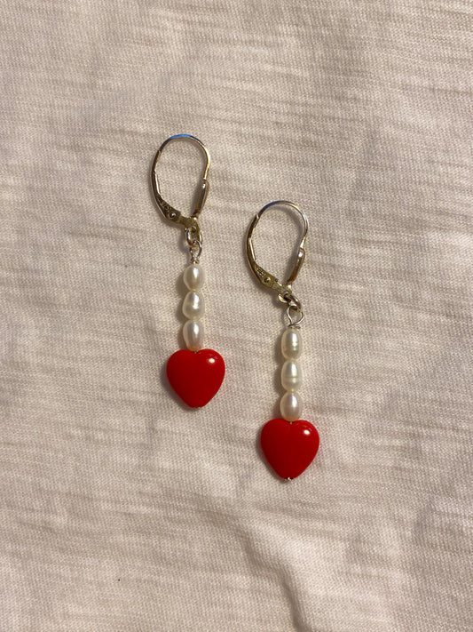 flat lay image of ruby heart earrings 