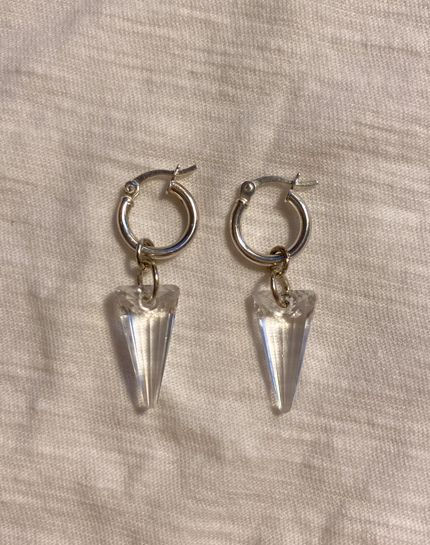 flat lay image of clear crystal spike earrings with sterling silver hoops 