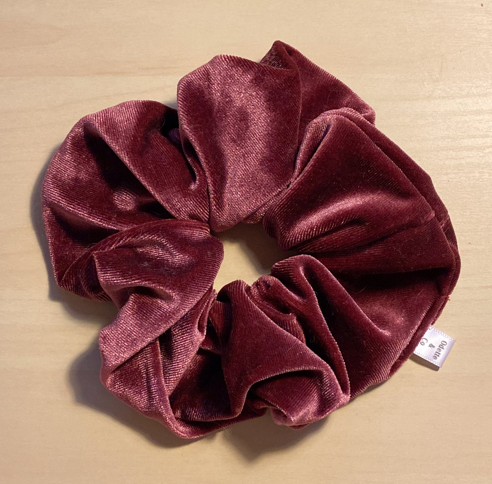 close up flat lay image of winter berry velvet scrunchie