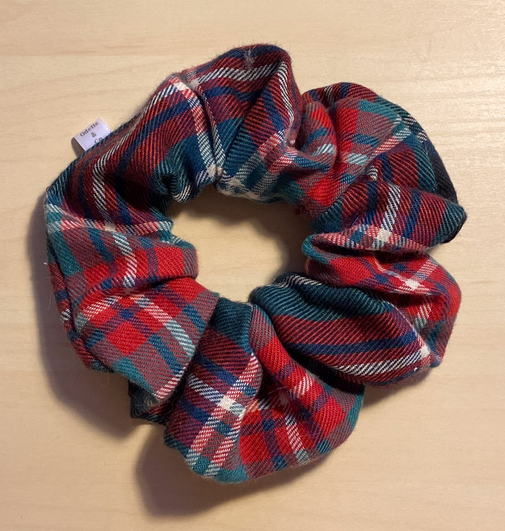 close up flat lay image of evergreen tartan scrunchie