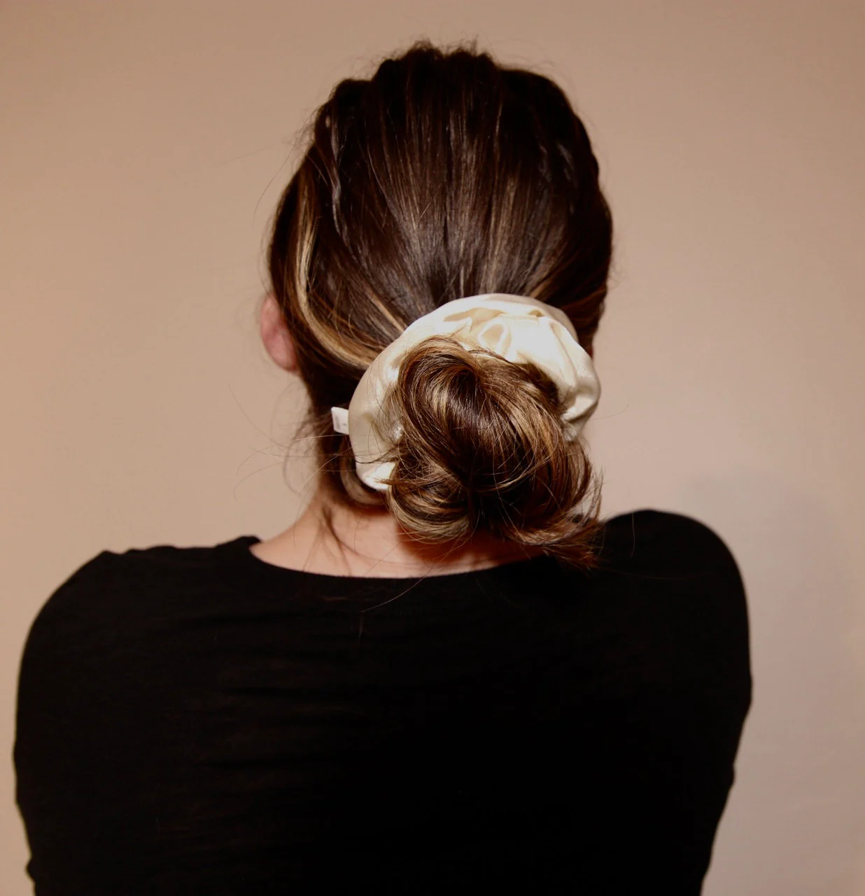 close up image, low bun featuring french vanilla satin scrunchie