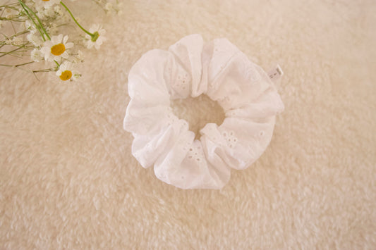 close up flat lay image of white eyelet cotton scrunchie 