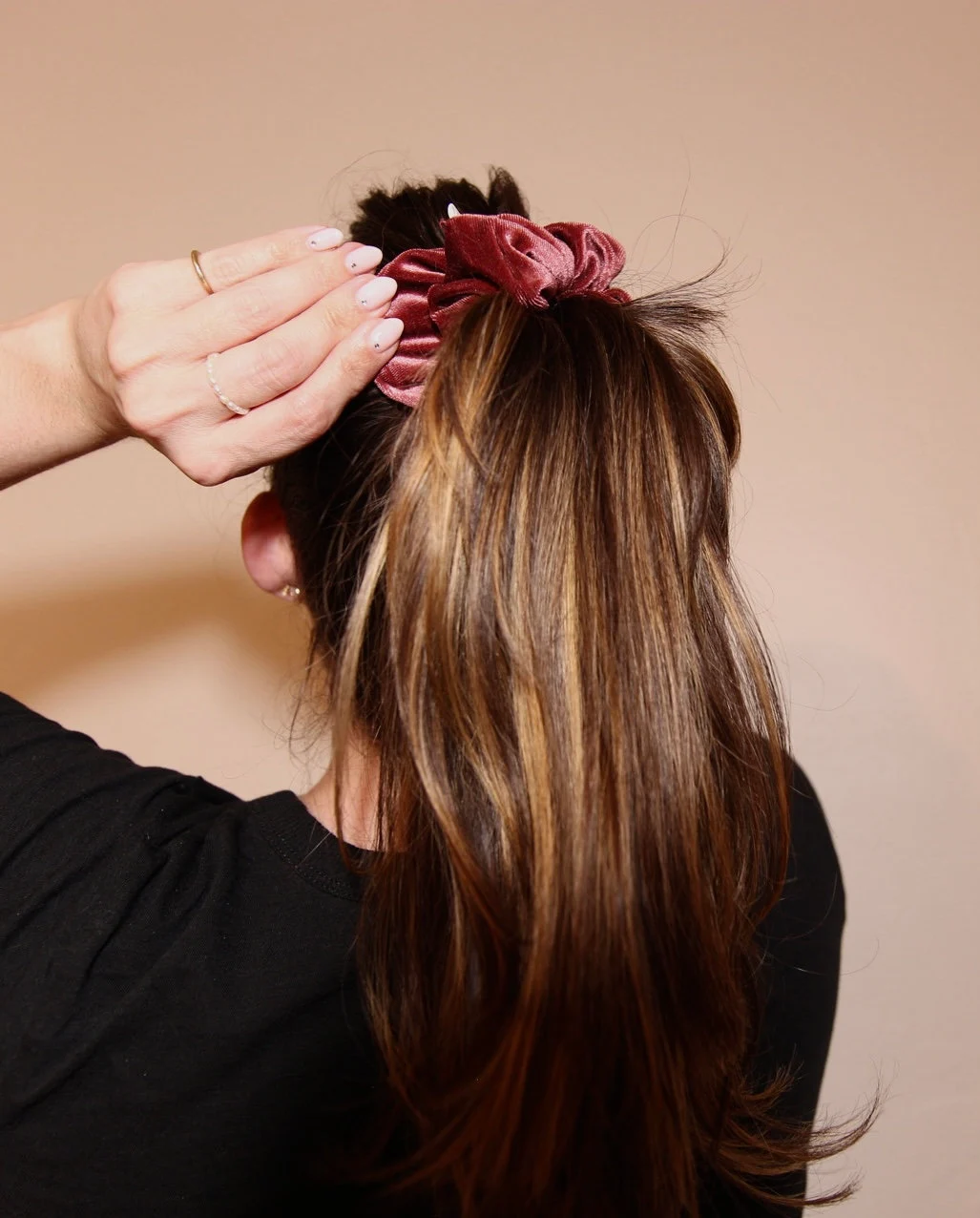 image of winter berry velvet scrunchie worn in high ponytail.