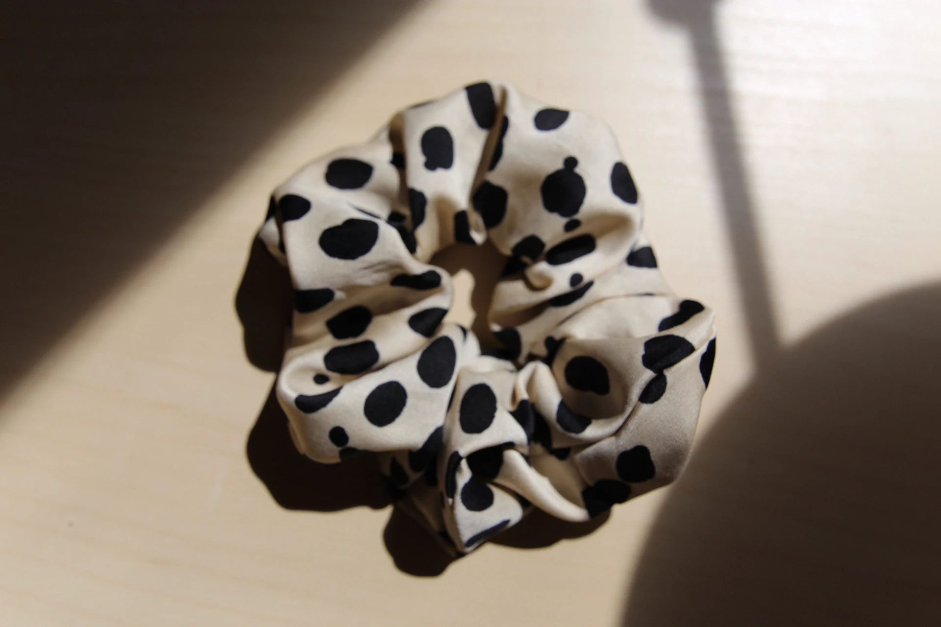 flat lay image of satin polka dot scrunchie