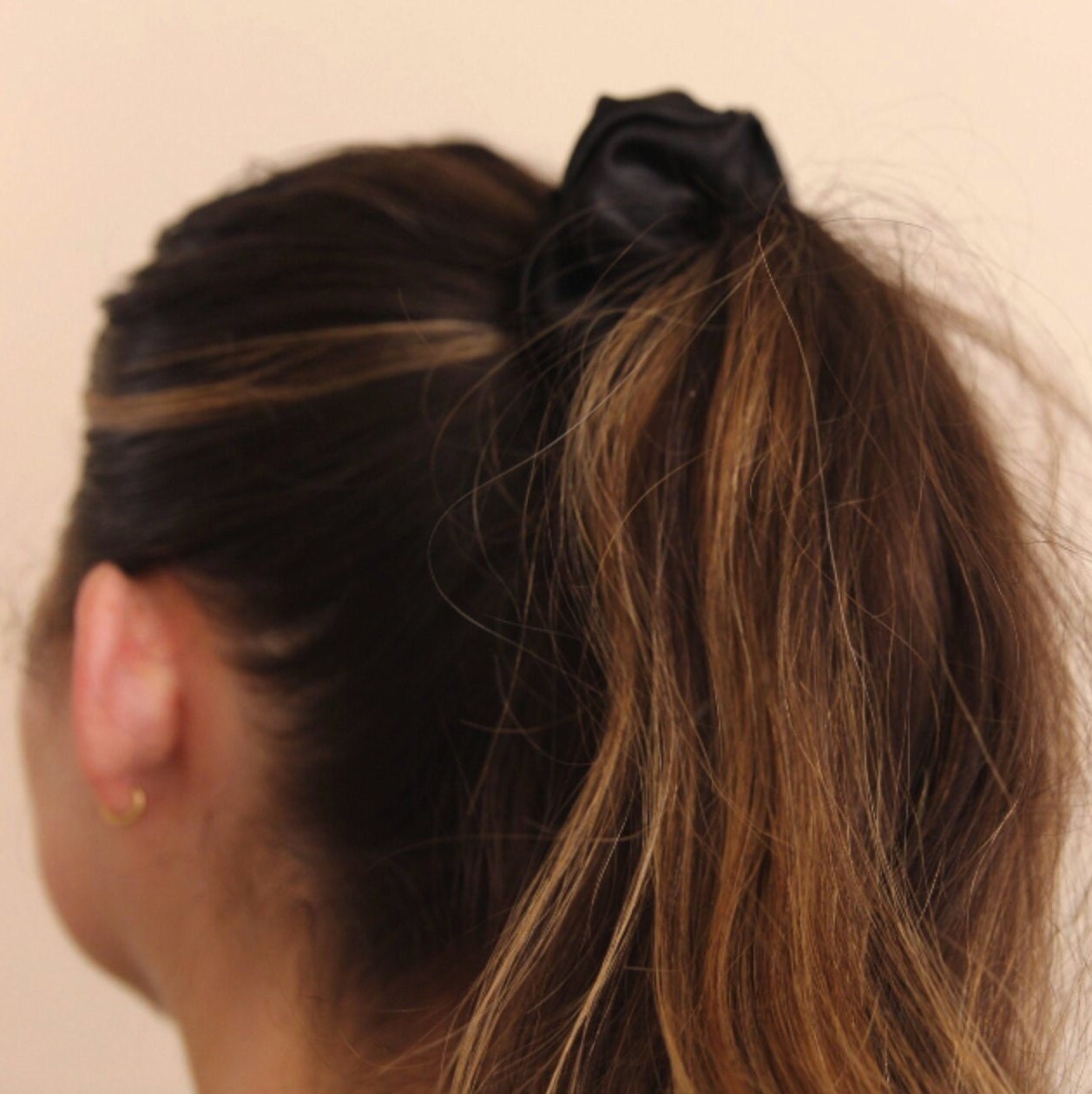 photo of hair tied in ponytail featuring black satin scrunchie