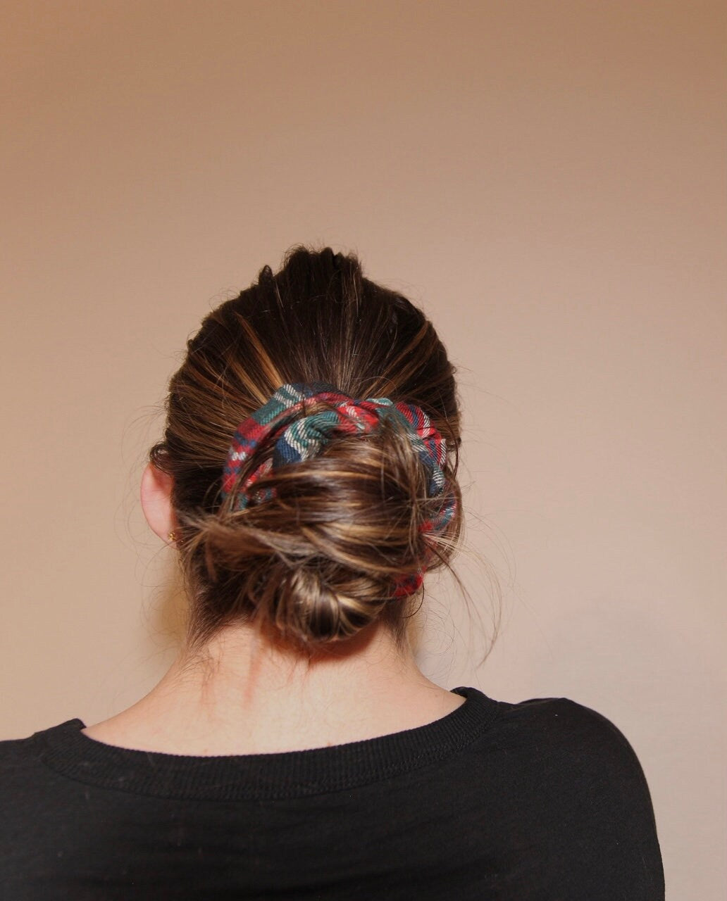 image of hair tied in low bun with evergreen scrunchie