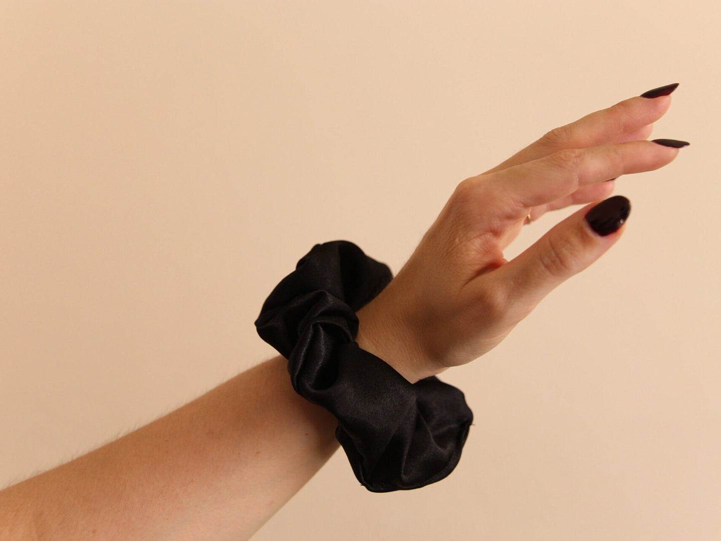 black satin scrunchie modeled on wrist